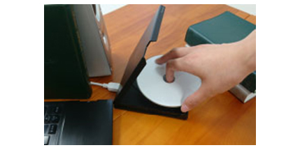 A disc is being inserted into a burner